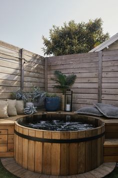 a wooden hot tub sitting on top of a lush green field