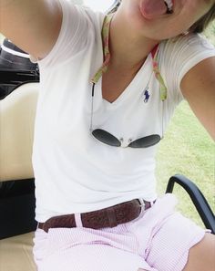 a woman sitting in the back of a golf cart with her mouth open and tongue out