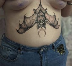 a woman's stomach with a bat tattoo on her belly and the bottom part of her abdomen