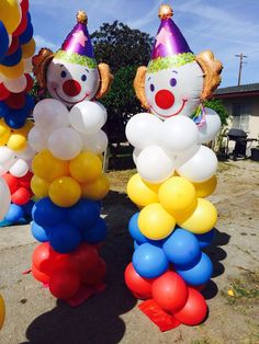 two clowns are sitting on top of balloons in the shape of people's heads