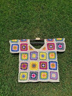 a crocheted shirt is laying on the grass