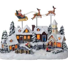 a lighted christmas village with santa and his sleigh