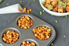 a muffin tin filled with cooked food next to a bowl of vegetables