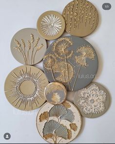 a bunch of different types of decorative plates on a white surface with gold and silver accents