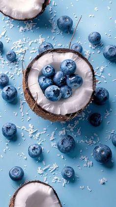 some blueberries and coconuts on a blue surface with white sprinkles