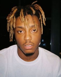 a close up of a person with dreadlocks wearing a white t - shirt