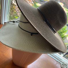 "Vegan leather chin cord with adjustable bead, adjustable inner drawstring. -100% straw Measures: Brim is 17.5\", Crown is 7.5\" x 7.5\" x 4.5\"" Adjustable Casual Hats With Ties, Casual Hats With Adjustable Ties, Adjustable Straw Sun Hat For Outdoor, Adjustable Fedora Sun Hat For Travel, Adjustable Braided Hat Bands For Spring, Adjustable Pre-tied Spring Hat, Adjustable Brown Hat Band For Beach, Adjustable Fedora Straw Hat For Outdoor, Adjustable Brown Hat Bands For The Beach