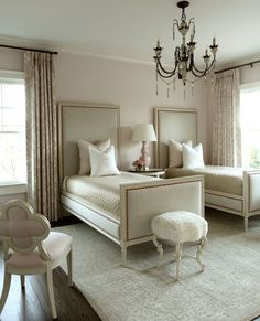 a bedroom with two beds and a chandelier