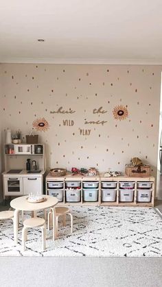 a playroom with sunflowers on the wall and storage bins for children's toys