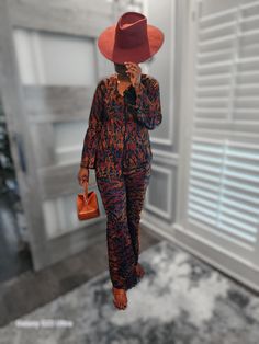 This ankara printed dark, patterned suit with rich autumn tones. The jacket is a relaxed fit, paired with matching straight-leg pants. Floral Print Sets For Workwear In Fall, Long Sleeve Pantsuit For Fall Loungewear, Brown Workwear Sets For Fall, Brown Sets For Workwear In Fall, Multicolor Workwear Sets For Fall, Multicolor Sets For Workwear In Fall, Multicolor Sets For Fall Workwear, Chic Fall Pantsuit For Loungewear, Patterned Suit