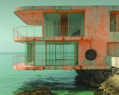 an old building sitting on top of a cliff next to the ocean