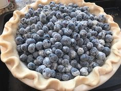 a pie crust filled with blueberries sitting on top of a stove