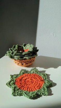 two small crocheted baskets sitting on top of a white table next to each other