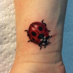 a lady bug tattoo on the wrist