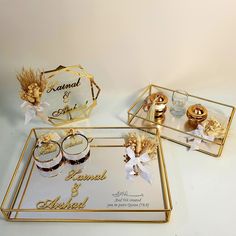 two gold trays with wedding rings and candles on them, one for the bride