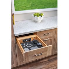 an open drawer on the side of a kitchen counter