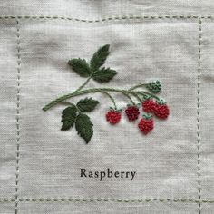 a close up of a piece of cloth with raspberry embroidered on the side