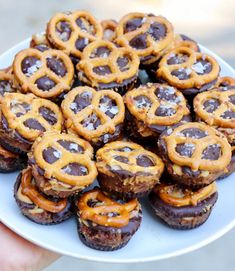 a white plate topped with mini chocolate covered pretzel bites on top of each other