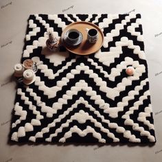 a black and white rug with two cups on it