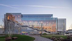 a large building with many windows on the front and side of it, in a park area