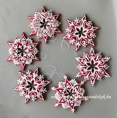 six snowflakes arranged in a circle on a gray background with white and red designs