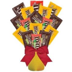 a bouquet of candy bars wrapped in red and yellow paper with a bow on top