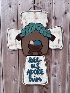 a wooden sign that says let us adore him on the side of a fence