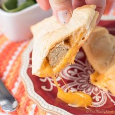 a person dipping cheese on top of a piece of bread