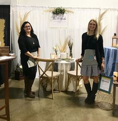 two women standing next to each other in front of a table with an apron on it