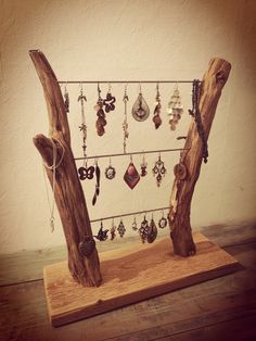 there is a wooden stand with earrings hanging from it's sides and two pieces of wood on the other side