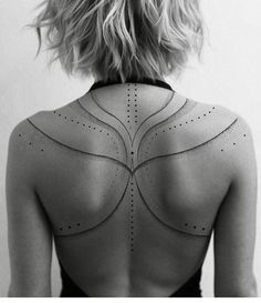 the back of a woman's neck with lines on it and dots all over her body