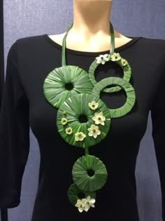 a green necklace with white flowers on it