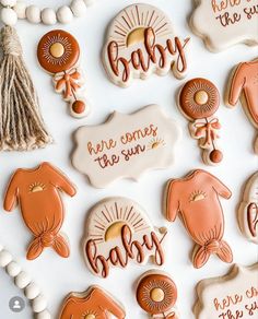 some cookies that are decorated to look like babys and the words'here comes the sun '