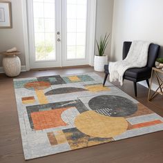 a living room with a large rug on the floor and a chair in front of it