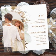 a wedding card with an image of a man and woman in the background, surrounded by seashells