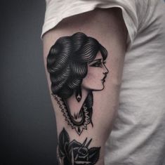 a woman's arm with a black and white tattoo design on the left upper arm