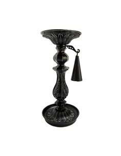 a black candle holder with a tassel hanging from it's side and an ornate design on the base