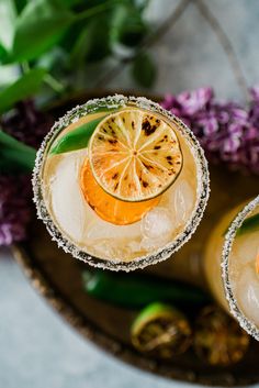 two glasses filled with orange juice and garnished with silver glitters on the rim