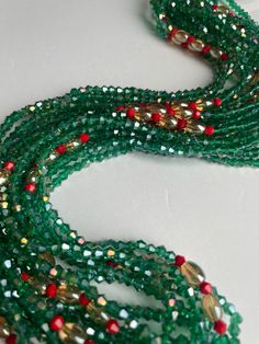 Elastic waist beads, made by skilled artisans in the Ivory Coast. This striking piece features deep green crystal glass seed beads complemented by vibrant red crystal glass seed bead accents, blending nature's tranquility with bold energy. Cultural Significance: In the Ivory Coast, waist beads hold deep cultural meaning as symbols of femininity, sensuality, and personal growth. Traditionally worn to celebrate significant life events, these beads connect wearers to their heritage and empower their personal journeys. Design and Craftsmanship: Materials: High-quality crystal glass seed beads Colors: Deep Green: Represents growth, harmony, and renewal Red Accents: Symbolizes passion, vitality, and strength Fit: Elastic band ensures a comfortable and flexible fit for all body types Wear with Pu Green Round Beads Spiritual Crystal Necklace, Adjustable Green Beads For Festive Occasions, Festive Green Beaded Bracelets With Colorful Beads, Festive Green Beaded Bracelets, Traditional Green Faceted Beaded Necklaces, Green Spiritual Beaded Necklace With Colorful Beads, Green Multi-strand Beads For Gifts, Traditional Green Beaded Bracelets With Spacer Beads, Bohemian Green Beads For Festive Occasions