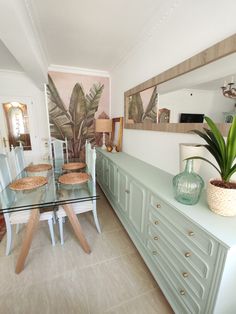 a dining room table and chairs in front of a mirror