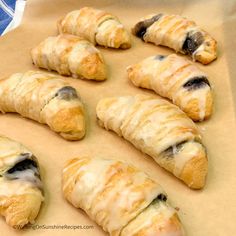 several croissants are lined up on a piece of parchment paper and ready to be baked