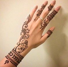 a woman's hand with henna tattoos on it