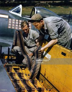 two men working on an airplane engine