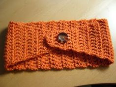 an orange crocheted purse sitting on top of a table