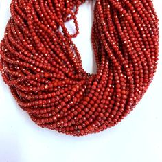 a red beaded necklace on a white background