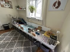 a room with several baskets on the floor and a rug in front of a window