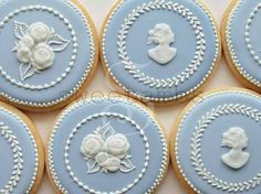 six decorated cookies with blue frosting and white icing