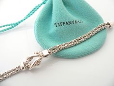 Do you know which items made Tiffany a world renowned company? You just stumbled upon one of them! Offered for sale is a wonderful vintage Tiffany and Co. Sterling Silver Double Rope Love Knot bracelet - in a rare longer length - 7.75 inches. The piece is made from solid and substantial Tiffany silver, yet has a very delicate and feminine feel to it. The bracelet is very unique - hard to find and come by, so grab it while you have the chance! It is very pretty worn on its own, but would also wor Luxury Bracelets With Sterling Silver Clasp For Anniversary, Elegant Sterling Silver Bracelet With Clasp For Gift, Engraved Chain Bracelet For Formal Occasions, Elegant Sterling Silver Bracelet With Box Clasp As Gift, Elegant Chain Bracelet With Clasp As Gift, Vintage White Gold Chain Bracelet For Formal Occasions, Luxury Sterling Silver Jubilee Bracelet As Gift, Luxury Chain Bracelet With Sterling Silver Clasp As Gift, Elegant Silver Bracelet With Hallmarks