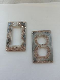 two decorative switch plates are shown on a white surface