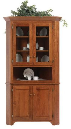 a wooden china cabinet with glass doors and plates on it's top, in front of a white background